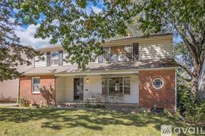 Kansas City house for rent - A house with a red brick chimney and a white garage door is for sale.