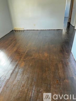Kansas City house for rent - A room with wooden flooring and a wall heater.