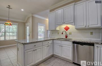 Little Rock house for rent - A kitchen with white cabinets and a black dishwasher.