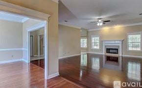 Little Rock house for rent - A spacious room with wood flooring and a fireplace.