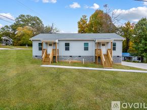 Knoxville townhouse for rent - A two-story house with a porch and stairs leading to the front door.