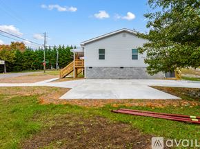Knoxville townhouse for rent - A small house with a grey roof and a wooden staircase leading to the front door.
