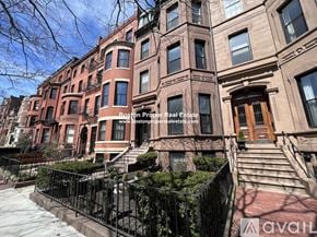 Boston apartment for rent - A row of brown brick townhouses with black metal railings.