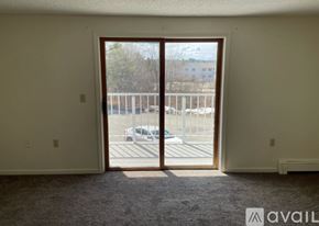 Bangor apartment for rent - A room with a carpeted floor and a large open door leading to a parking lot.