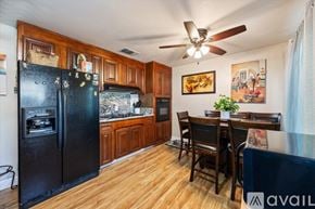 Sacramento house for rent - A kitchen with a black fridge and wooden cabinets.