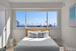 Huntington Beach condo for rent - A bedroom with a large bed and a view of the beach through the window.