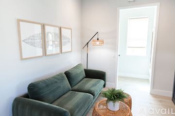 Huntington Beach condo for rent - A living room with a green couch and a small table with a plant on it.