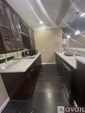 Aldie house for rent - A kitchen with dark wood cabinets and a marble countertop.