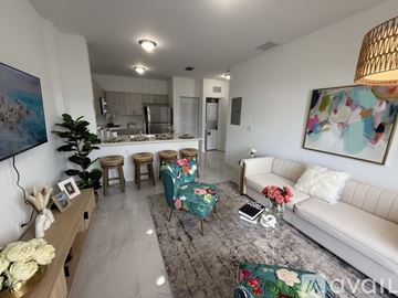 Miami apartment for rent - A living room with a white couch and a painting on the wall.