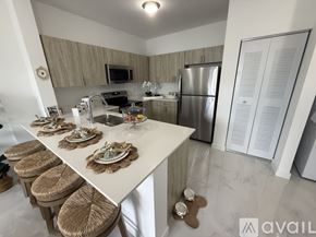 Miami apartment for rent - A kitchen with a white countertop and stools.
