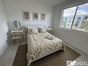 Miami apartment for rent - A bedroom with a large bed and a window overlooking a street.
