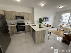 Miami apartment for rent - A kitchen with a refrigerator, stove, and sink.