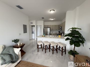 Miami apartment for rent - A kitchen with white cabinets and a white fridge is shown.