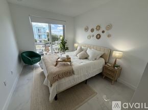 Miami apartment for rent - A bedroom with a large bed and a green chair.