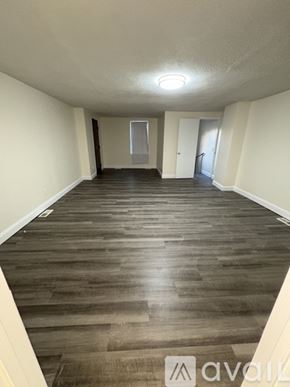 Boston apartment for rent - A long hallway with wood floors and white walls.
