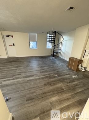 Boston apartment for rent - A room with wooden flooring and a spiral staircase.