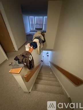 Boston apartment for rent - A staircase with a coat hanging on the railing.