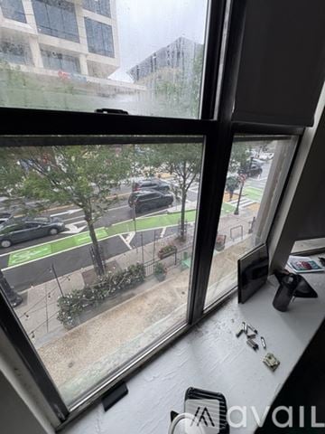 Boston apartment for rent - A view from a window looking out at a street with cars and buildings.