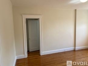 Boston apartment for rent - A room with a wooden floor and a white door.