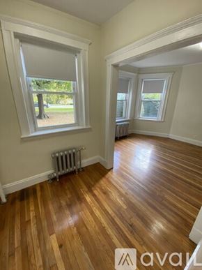 Boston apartment for rent - A room with wooden floors and a window with blinds.