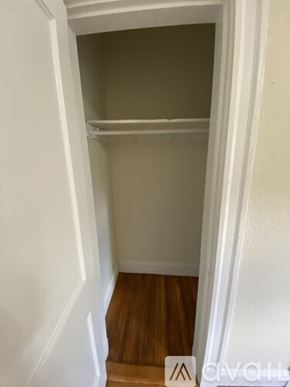 Boston apartment for rent - A white closet with a shelf and wooden floors.