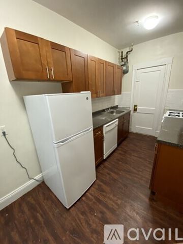 Boston apartment for rent - A kitchen with wooden cabinets and a white fridge.