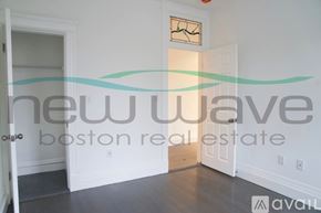 Boston apartment for rent - A room with a white door and a wall with a clock and a logo for New Wave Boston Real Estate.