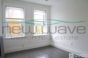 Boston apartment for rent - A room with a window and a wall with a logo for New Wave Boston Real Estate.