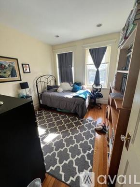Boston apartment for rent - A bedroom with a bed, a chair, and a rug.