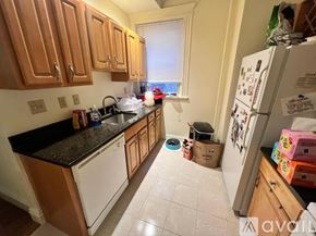 Boston apartment for rent - A kitchen with wooden cabinets and a black countertop.