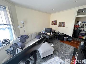 Boston apartment for rent - A living room with a white couch and a grey ottoman.