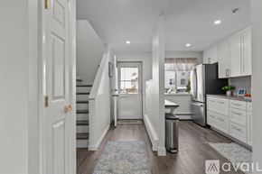 Newport condo for rent - A kitchen with white cabinets and a stainless steel refrigerator.