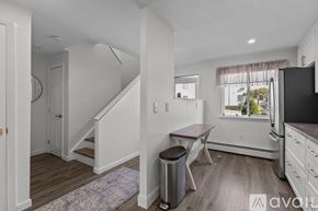Newport condo for rent - A kitchen with white walls and wooden floors.