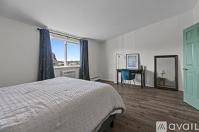 Newport condo for rent - A bedroom with a large bed and a desk with a chair.