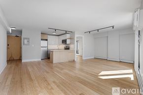 Chicago apartment for rent - A spacious room with wooden flooring and white walls.