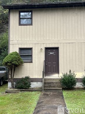 Prestonsburg apartment for rent - A house with a brown door and a small tree in front.