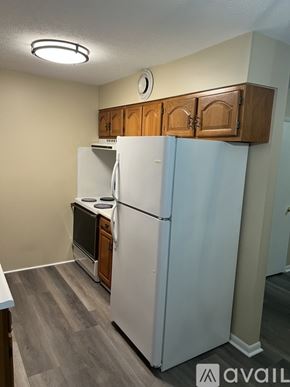 Prestonsburg apartment for rent - A white refrigerator in a kitchen with wooden cabinets.