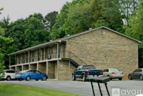 Morristown apartment for rent - A parking lot with cars and a building in the background.