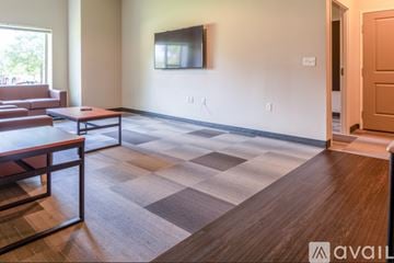 Whitewater apartment for rent - A living room with a brown couch and a wooden floor.