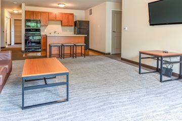 Whitewater apartment for rent - A modern kitchen with a dining table and a living room area.