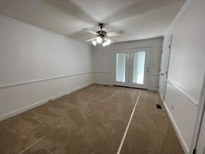 Wilson apartment for rent - A room with a carpeted floor and a ceiling fan.