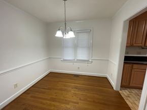 Wilson apartment for rent - A room with wooden floors and a window with blinds.
