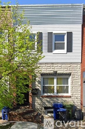 Baltimore townhouse for rent - A house with a window and a tree in front of it.