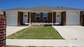 Fort Worth house for rent - A house with a white garage door and a brick wall in front.