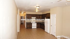 Fort Worth house for rent - A room with a white door and a wooden cabinet.