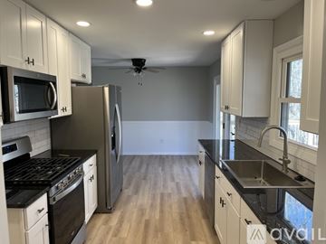 Rockford house for rent - A kitchen with white cabinets and black countertops.