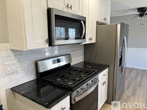 Rockford house for rent - A kitchen with white cabinets and a black stove top oven.
