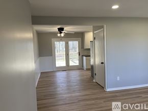 Rockford house for rent - A spacious room with wooden flooring and a ceiling fan.