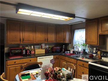 Lemont Furnace house for rent - A kitchen with wooden cabinets and a table with a cake on it.