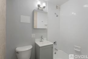 Chicago apartment for rent - A bathroom with a toilet, sink, and mirror.